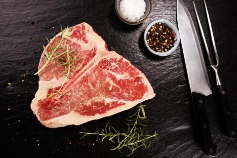 T-bone steak raw on stone board Stock Photos