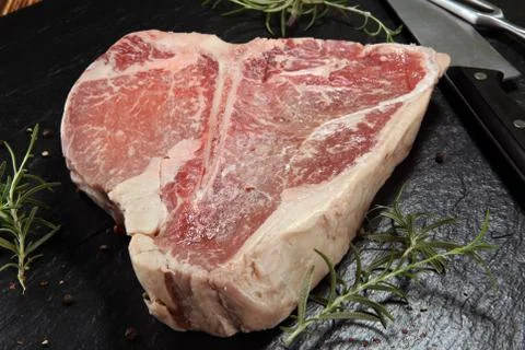 T-bone steak raw on stone board Stock Photos