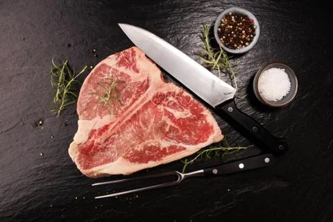T-bone steak raw on stone board Stock Photos