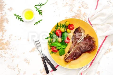 T-bone steak ready to eat, served on a plate, view from above Stock Photos