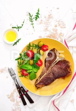 T-bone steak ready to eat, served on a plate, view from above Stock Photos
