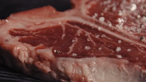 T-bone steak sprinkled with ground pepper Stock Footage 113081564