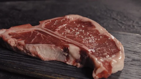 T-bone steak sprinkled with salt Stock Footage 113081597
