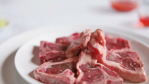T Bone steak on white plate, sauce and oil. Juicy raw T bone Stock Footage 130406840