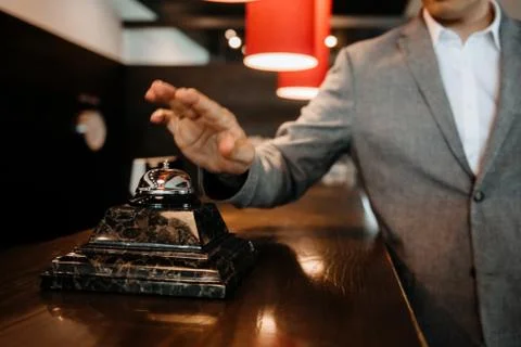 T the guy clicks on the bell at the reception of the hotel Stock Photos