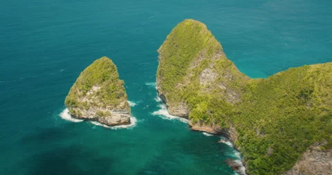 T Rex shaped cliffs of Kelingking Beach rise from the blue ocean in Bali Nusa Stock Footage 341369240