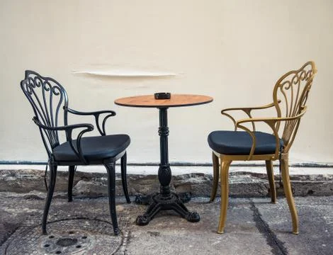 A table with 2 chairs next to a wall. Street cafe in the center of Bucharest Stock-Fotos