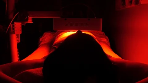 Table adjusting as lamp is on client stomach 스톡 동영상 107757539