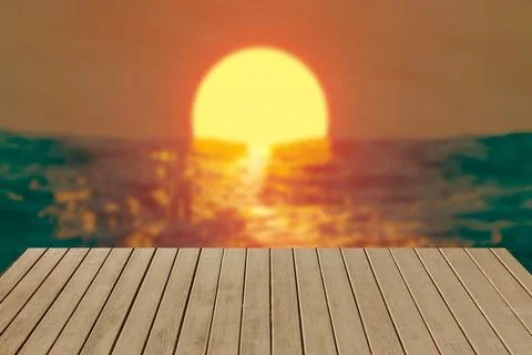 Table against the backdrop of a sunset in the sea. Stock Photos