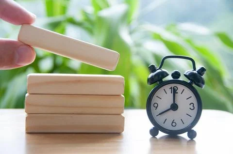 Table alarm clock pointing at 8 am with wooden blocks with customizable spa.. Stock Photos