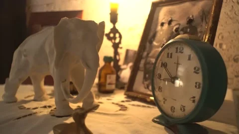 A table with an alarm clock, a statue of an elephant. photo scary Video stock 142652781