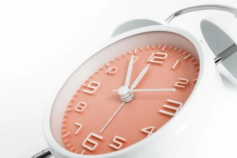 Table alarm clock with time 5 to 12 with orange clock face, 11.55 AM PM, on w Stock Photos