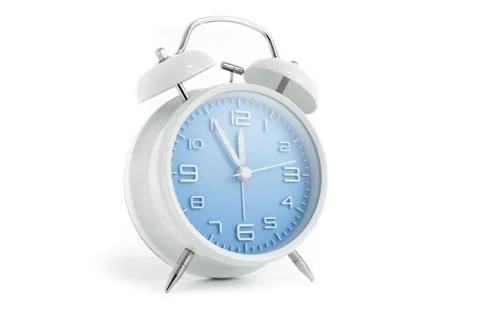 Table alarm clock with time 5 to 12 with blue clock face, 11.55 AM PM, on whi Stock Photos