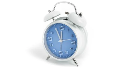 Table alarm clock with time 5 to 12 with blue clock face, 11.55 AM PM, on whi Stock Photos