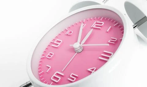 Table alarm clock with time 5 to 12 with pink clock face, 11.55 AM PM, on whi Stock Photos