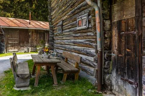 Table and benches in front of an old traditional wood chalet on the alpine me Foto stock