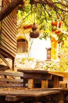 A table and benches under a tree with a lantern hanging Stock Photos