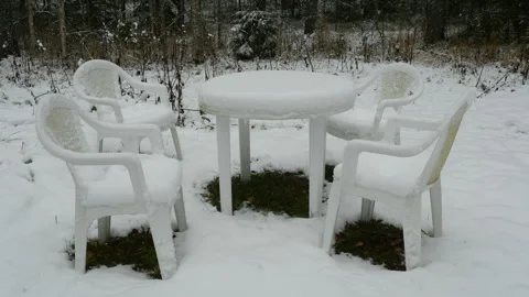 Table and chairs are covered with snow, snow falling. No people Stock Footage 102044664