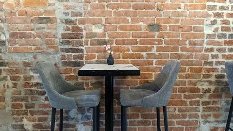 Table and chairs on the background of a brick wall Stock Photos