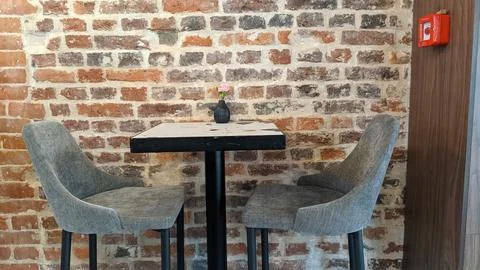 Table and chairs on the background of a brick wall Stock Photos