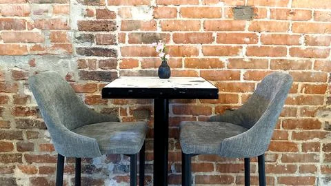 Table and chairs on the background of a brick wall Stock Photos