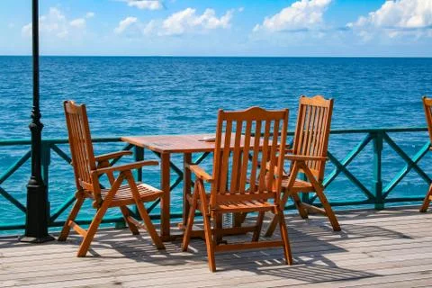 Table and chairs on the beach seafront Stock Photos