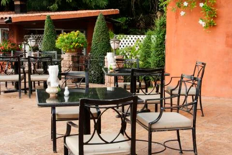Table and chairs set up outside a building Stock Photos