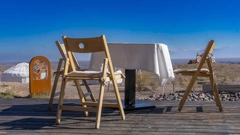 Table and chairs in the steppe, on the background of a yurt Stock Photos