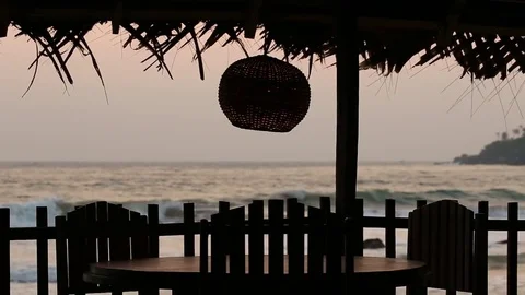 Table and lamp in a tropical cafe on the beach at sunset Stock Footage 70406093