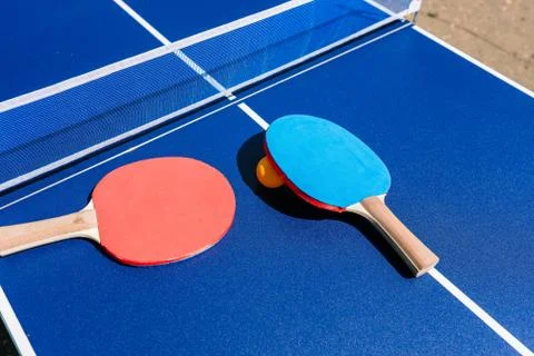 Table and rackets for playing table tennis or ping-pong. Blue table with whit Stock Photos