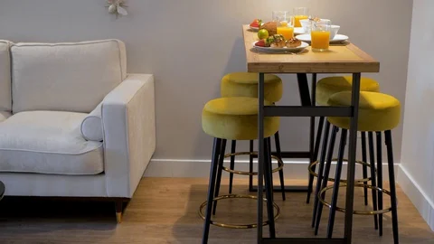 Table and sofa in a room. Breakfast with corn flakes, fresh strawberry Vidéo 129218024