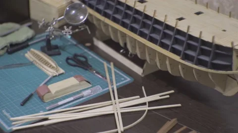 Table and tools with a model of a sailboat under construction Video stock 169400523