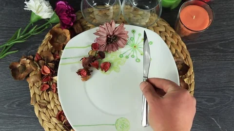 Table appointments- plate, fork, knife serving by human hands on decorative  Stock Footage 81663876