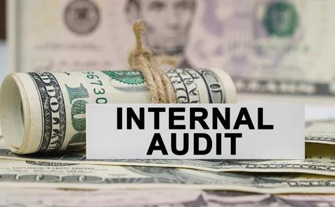 On the table are bills, a bundle of dollars and a sign on which it is written Stock Photos