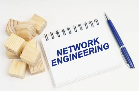 On the table are cubes, a pen and a notebook with the inscription - Network E Stock Photos