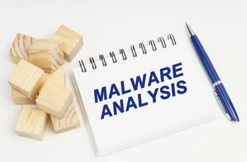 On the table are cubes, a pen and a notebook with the inscription - Malware A Stock Photos
