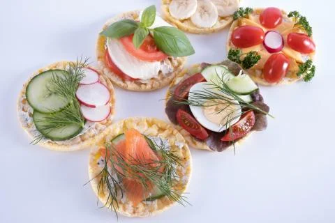 On the table are a cucumber, egg, tomatoes, bananas and radishes on corn wafe Stock Photos