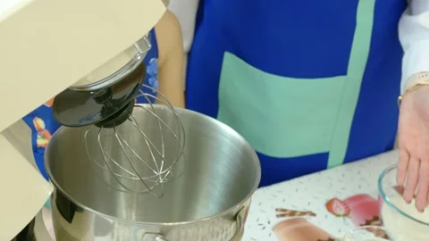On the table are kitchen utensils, a white planetary mixer with a bowl, and Stock Footage 150846377