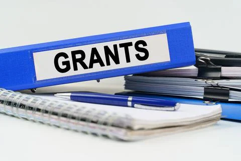 On the table are a notebook, a pen, documents and a folder with the inscripti Stock Photos