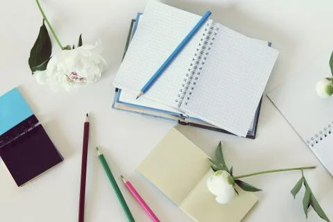 On the table are paper, books, empty notebooks, pencils Stock Photos