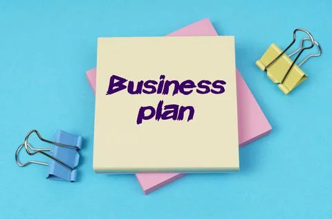 On the table are paper clips, note paper with text - Business plan Stock Photos