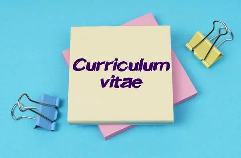 On the table are paper clips, note paper with text - Curriculum vitae Foto stock