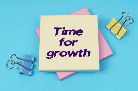 On the table are paper clips, note paper with text - Time for growth Foto stock