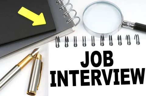 On the table are a pen and a notebook with the inscriptions - JOB INTERVIEW Stock Photos