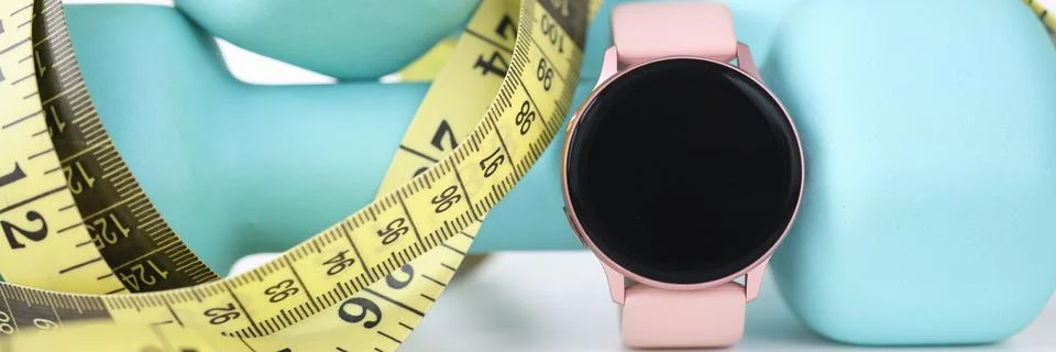 On table are smart watch dumbbell centimeter. 库存照片