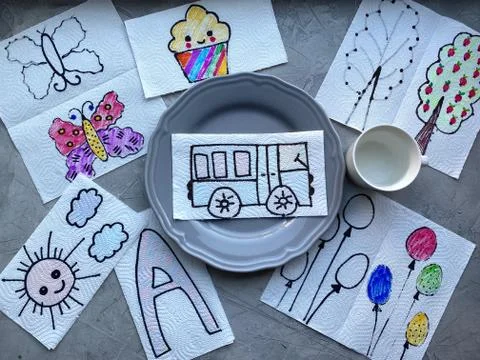 On the table are spread out children's drawings, depicted on a napkin, Stock Photos