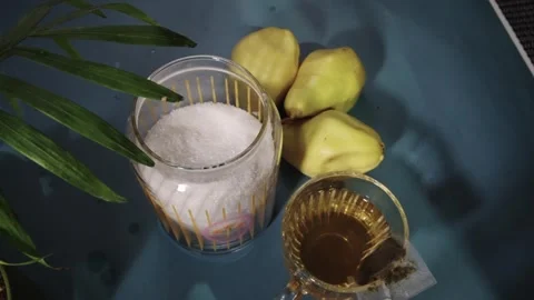 On the table are sugarv and an empty tea cup with a spoon. It is filled with tea Stock Footage 303639456