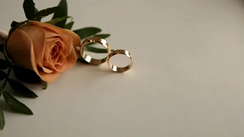 On the table are two wedding rings and a boutonniere Stock Footage 101818488