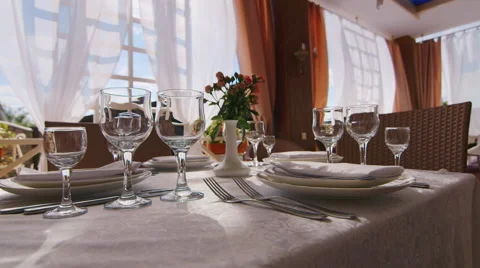 On the table are wine glasses, plates and cutlery. There is no one, the sun Stock Footage 64046843