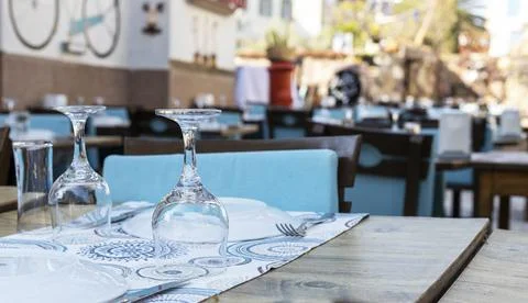 A table arranged inside the restaurant. Wine glasses and cutlery. Stock Photos